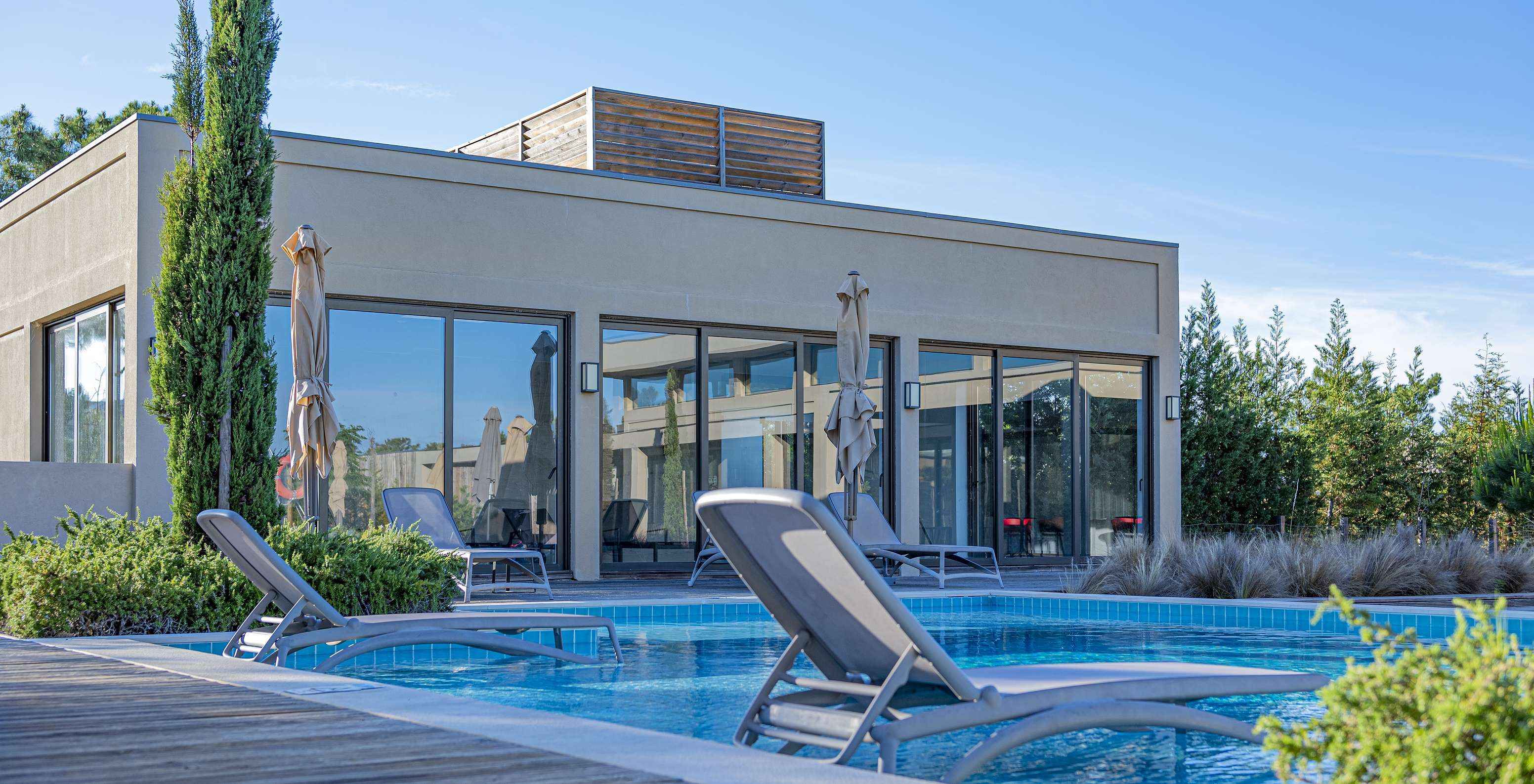 Buitenpool in Pestana Tróia Eco Resort met twee ligbedden in het water, waar je kunt ontspannen