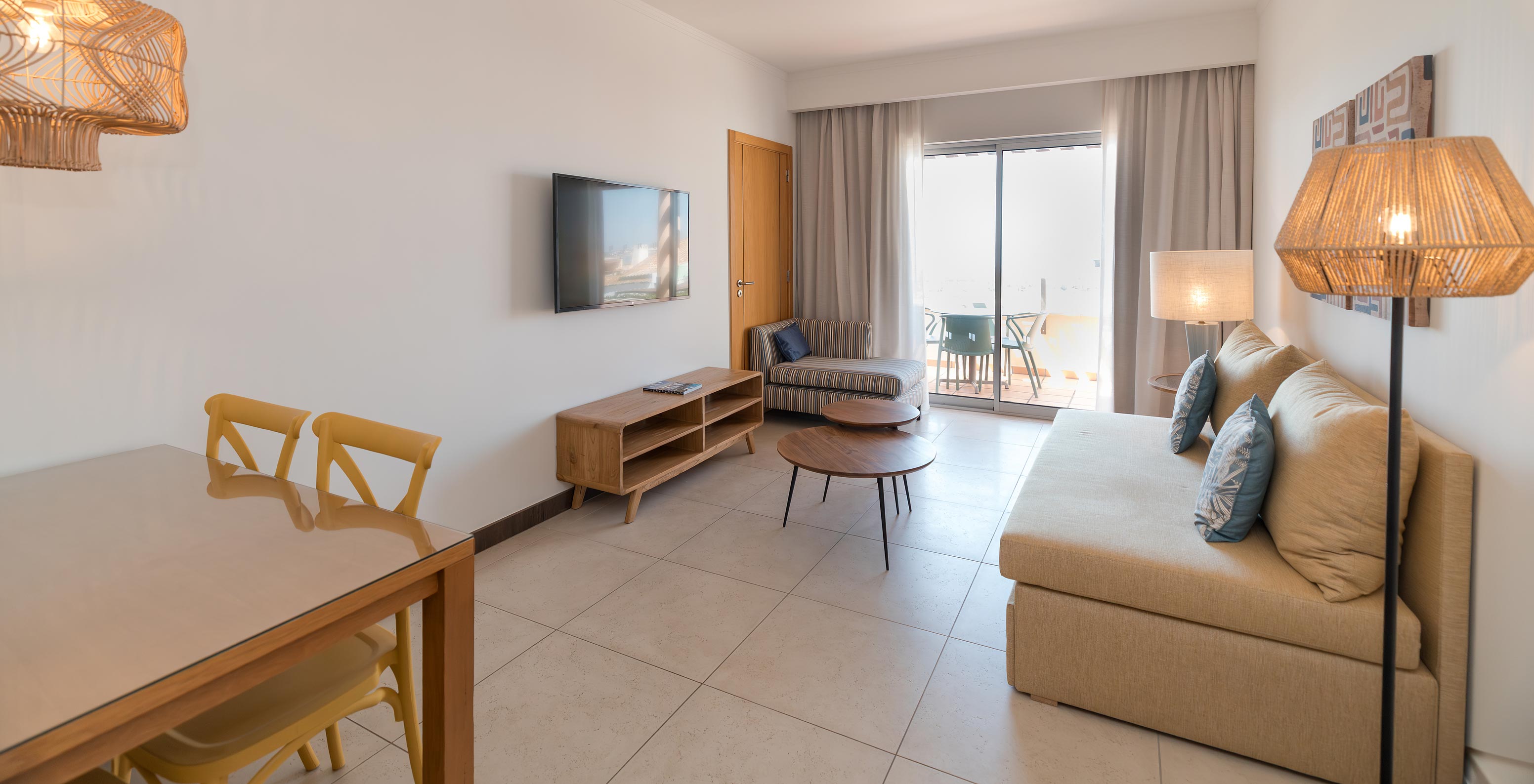 Appartement T1 Zeezicht bij Pestana Alvor Beach Villas heeft woonkamer met bank, tv en raam met toegang tot balkon