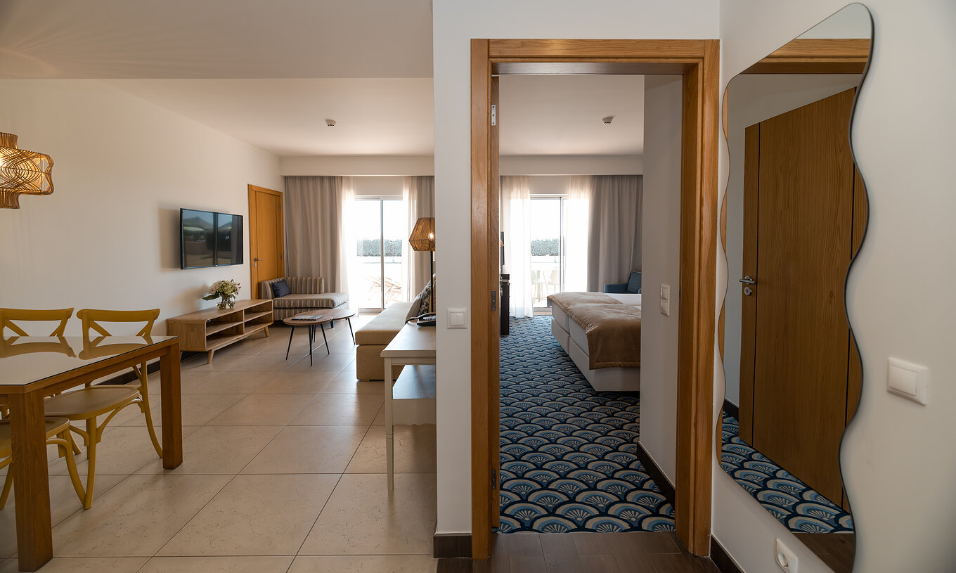 Appartement T1 Tuinzicht bij Pestana Alvor Beach Villas heeft een woonkamer met bank, tv en raam met balkon