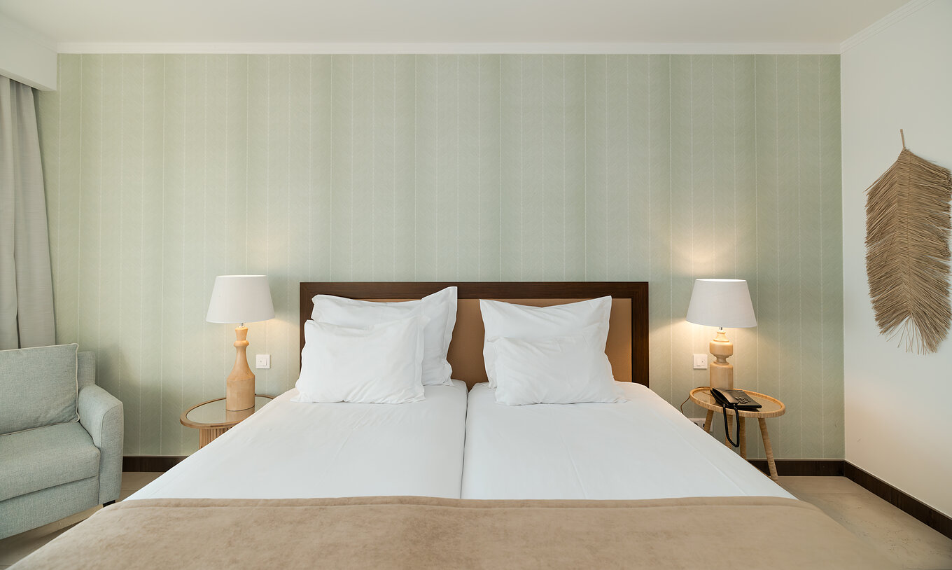 Studio Tuinzicht bij Pestana Alvor Beach Villas heeft twee bedden met nachtkastje en groen behang