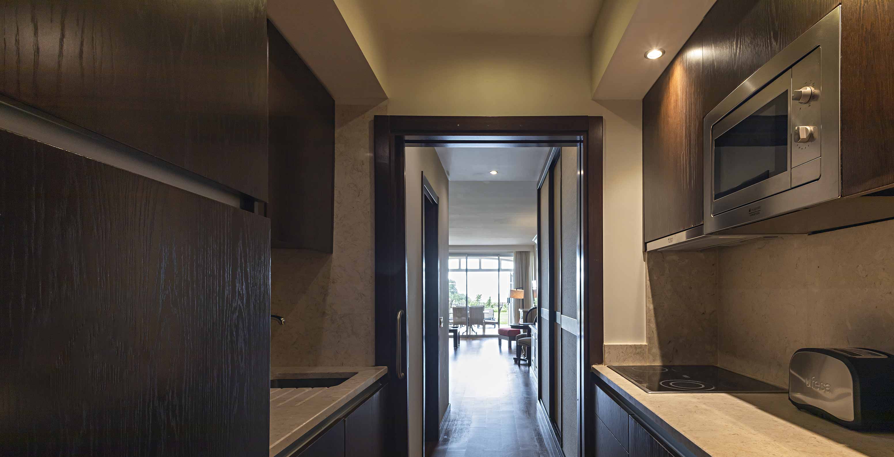 Het Cliff Family in Pestana Alvor Praia heeft een uitgeruste keuken in donker hout en steen, met fornuis en magnetron