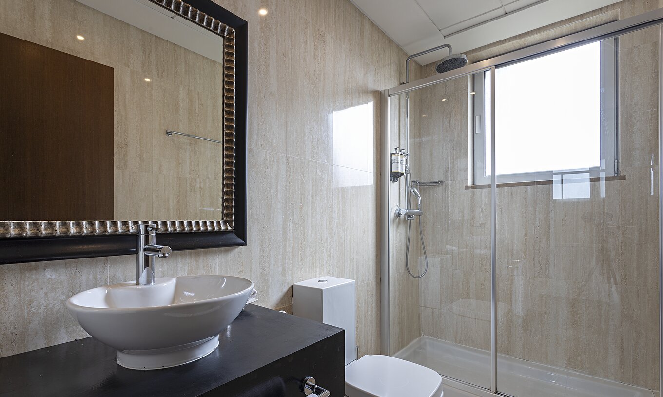 De Cliff Suite T2 in Pestana Alvor Praia heeft een moderne badkamer met een raam, een douche, een wastafel en een spiegel