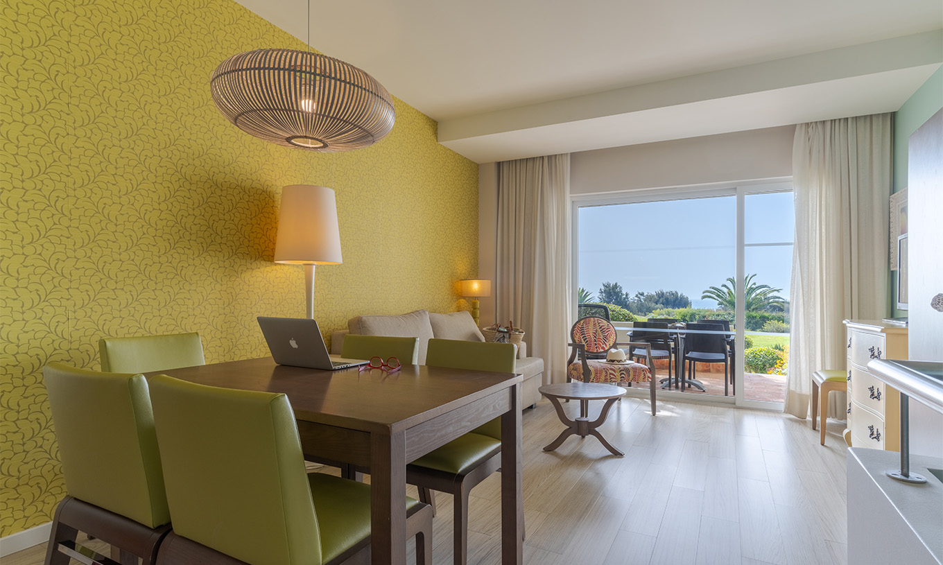 De Suite T1 Duplex met uitzicht op de zee van Pestana Alvor Praia heeft woonkamer met eettafel, stoelen, bank en balkon