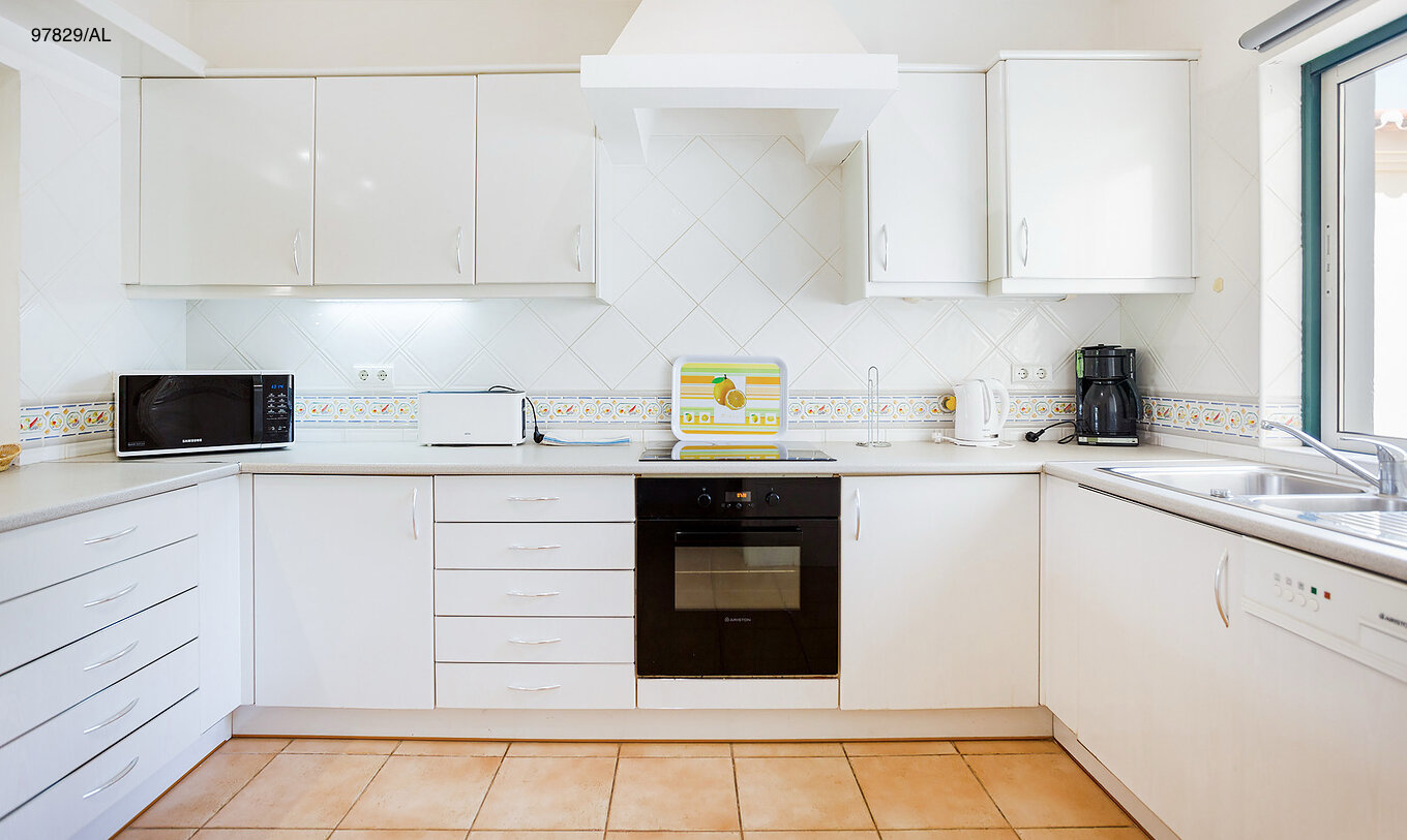 Het appartement Pestana Carvoeiro Golf T2 Standard heeft een keuken met witte kasten en een werkblad