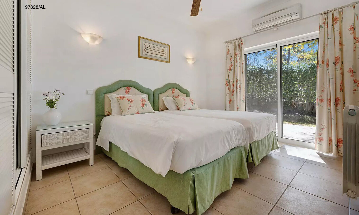 De villa Pestana Carvoeiro Golf V3 Standard heeft een slaapkamer met twee eenpersoonsbedden, een nachtkastje en een balkon