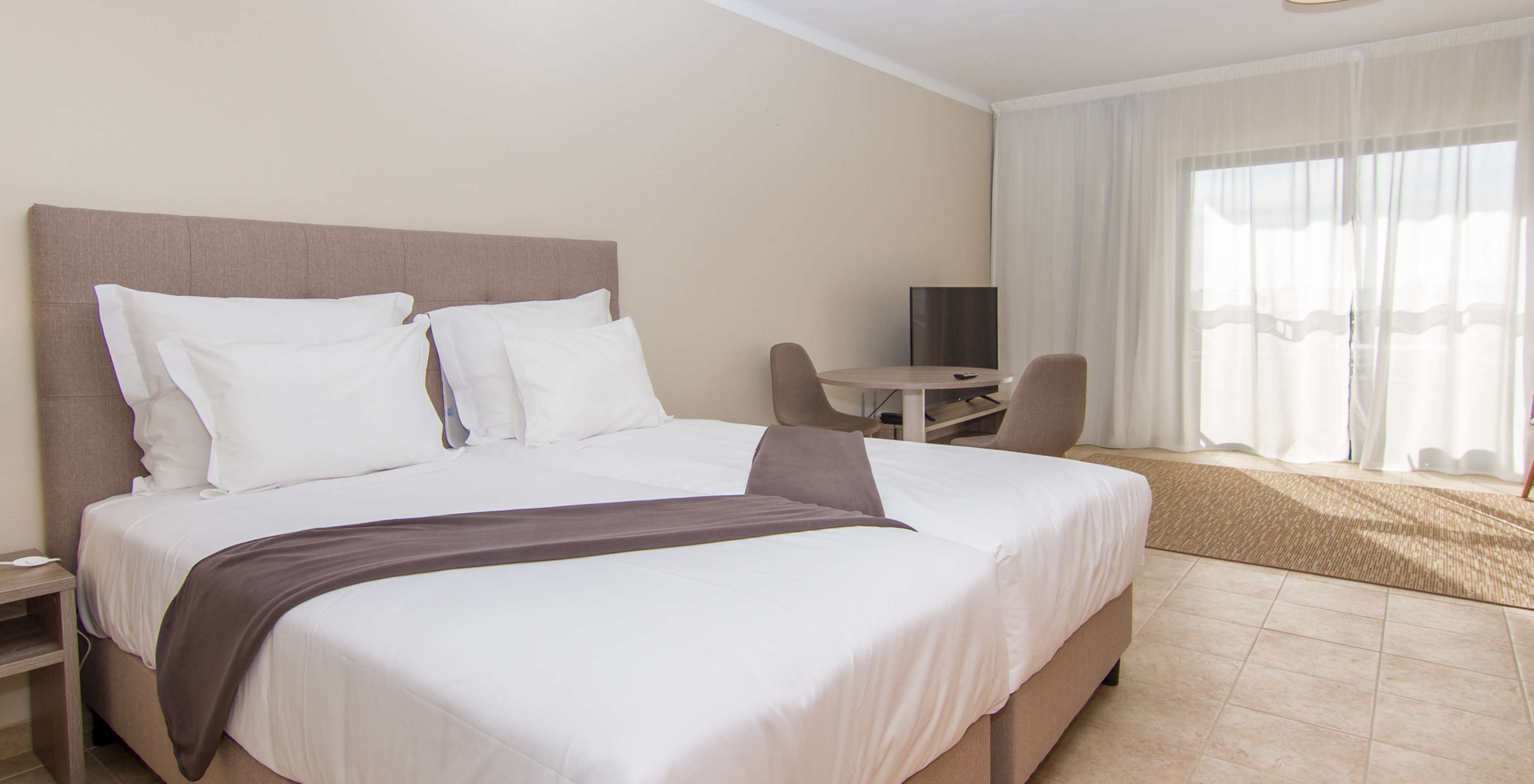 De Studio van Pestana Gramacho Residences heeft twee eenpersoonsbedden, een tafel met twee stoelen en een raam