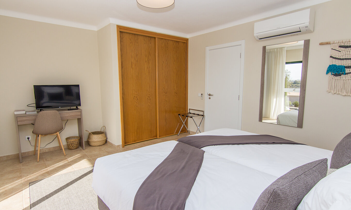 De Appartement T1 van Pestana Gramacho Residences heeft een spiegel aan de muur, airconditioning, kast en een televisie