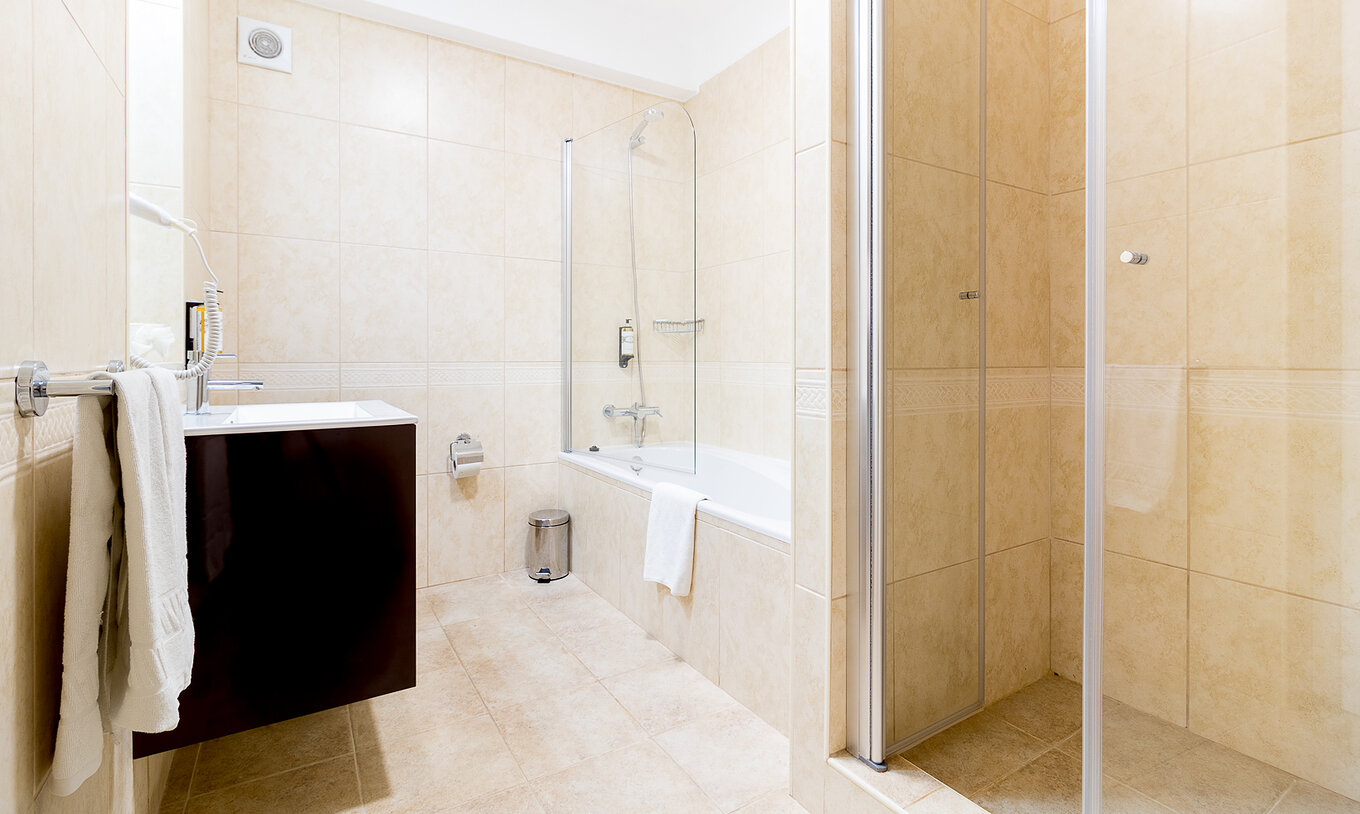 Het tweeslaapkamerappartement bij Pestana Gramacho heeft een lichte badkamer met bad, douche en moderne wastafel