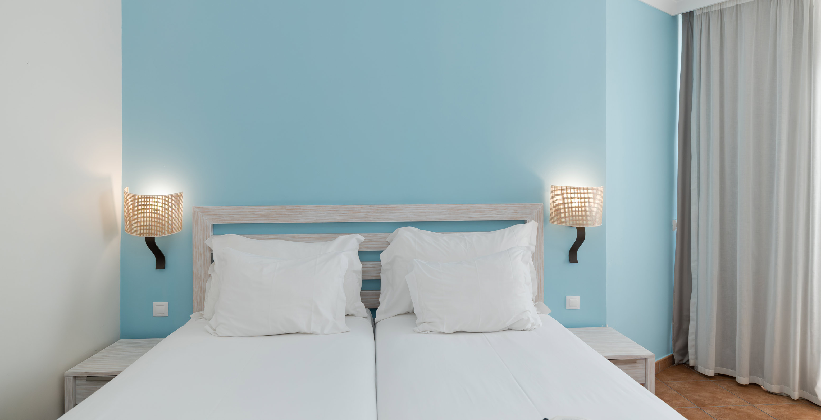 De Deluxe Tuinzicht van Pestana Viking heeft twee bedden, twee nachtkastjes en blauw behang