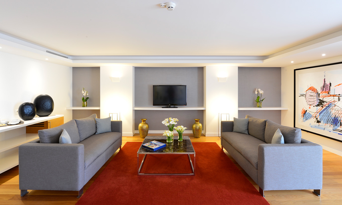 De Presidential Suite van Pestana Cidadela Cascais heeft een woonkamer met twee grote banken, een salontafel en een televisie