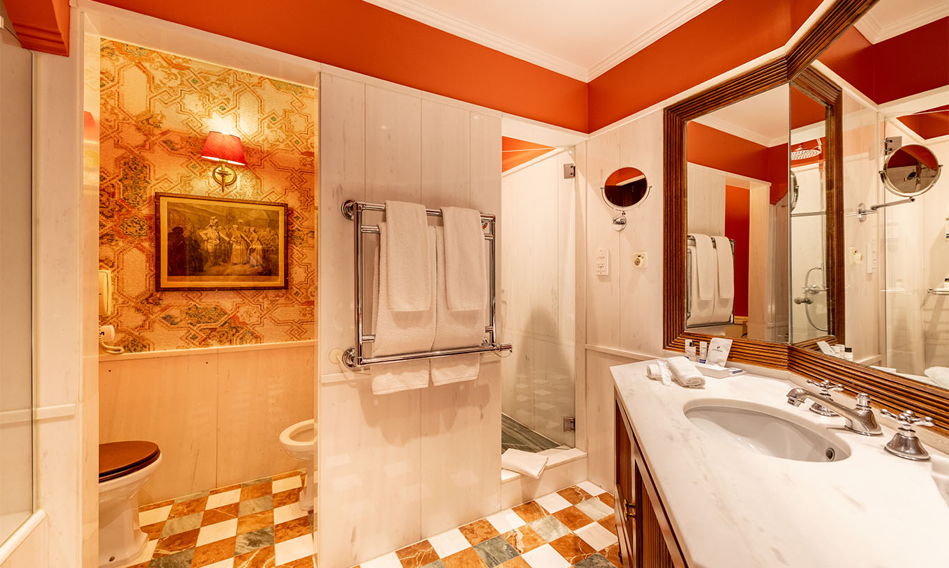 De Suite Collection van Pestana Palace Lisboa heeft een badkamer in wit marmer met ligbad, douche, toilet en handdoeken
