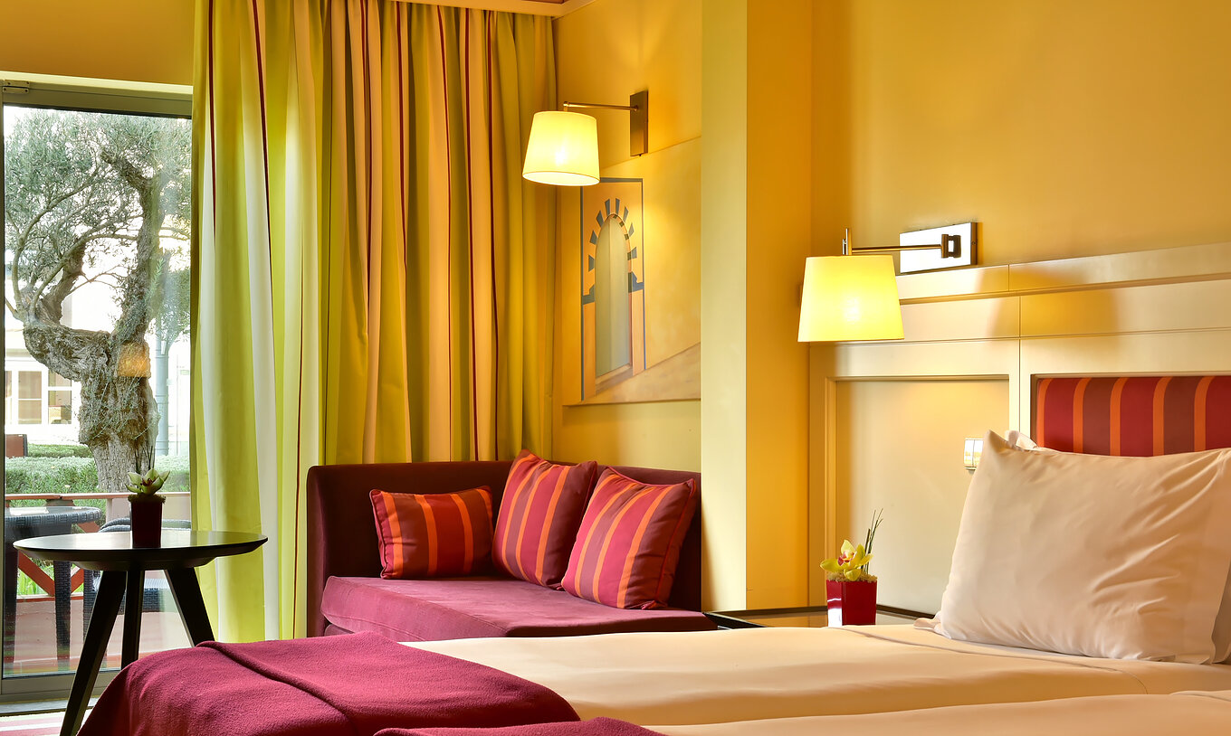 De Superior Tweepersoonskamer - Zwembadzicht van Pestana Sintra Golf heeft twee bedden, een bank met salontafel en een raam