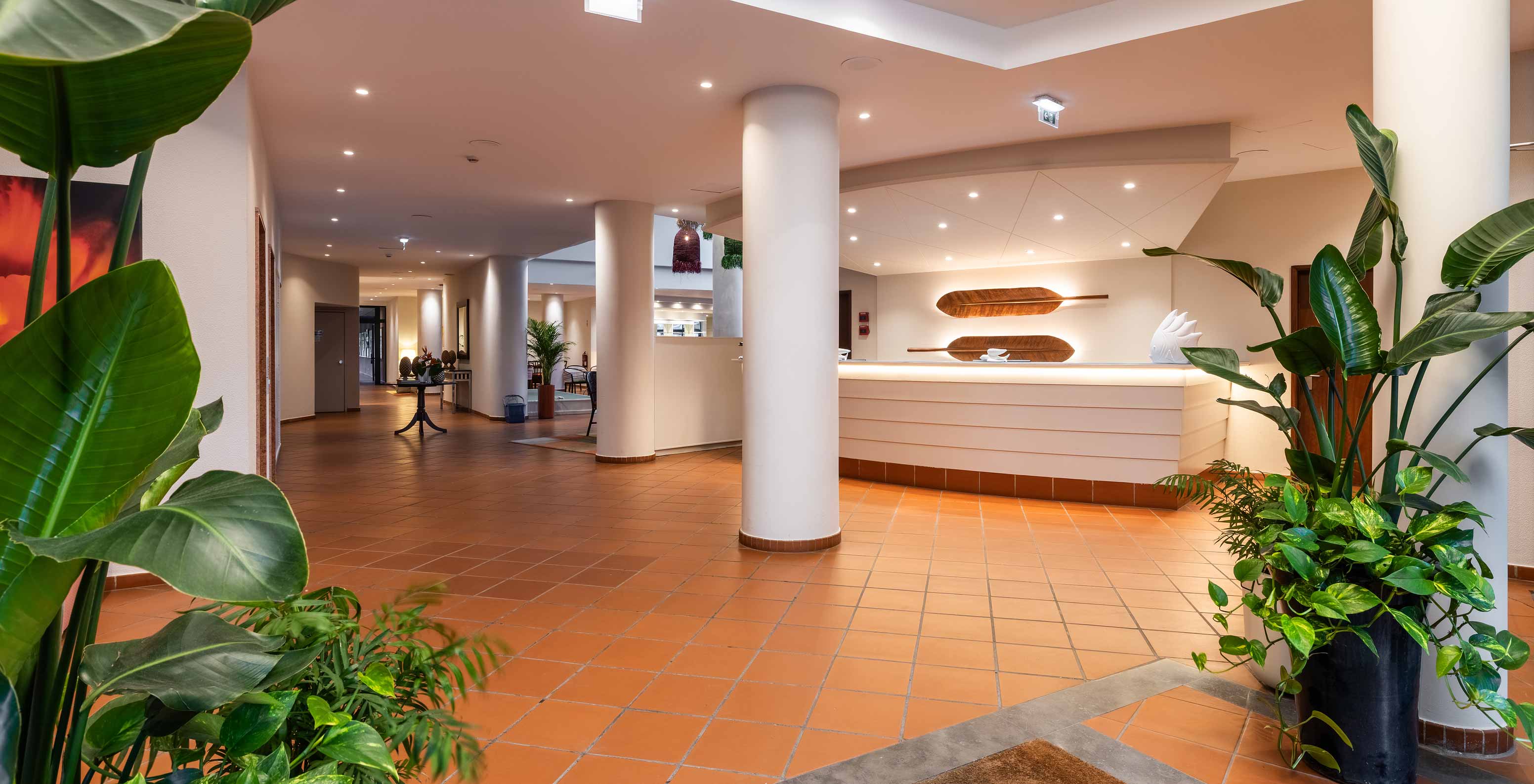 Pestana Ocean Bay All Inclusive, een all-inclusive hotel met een witte receptie die is versierd met planten