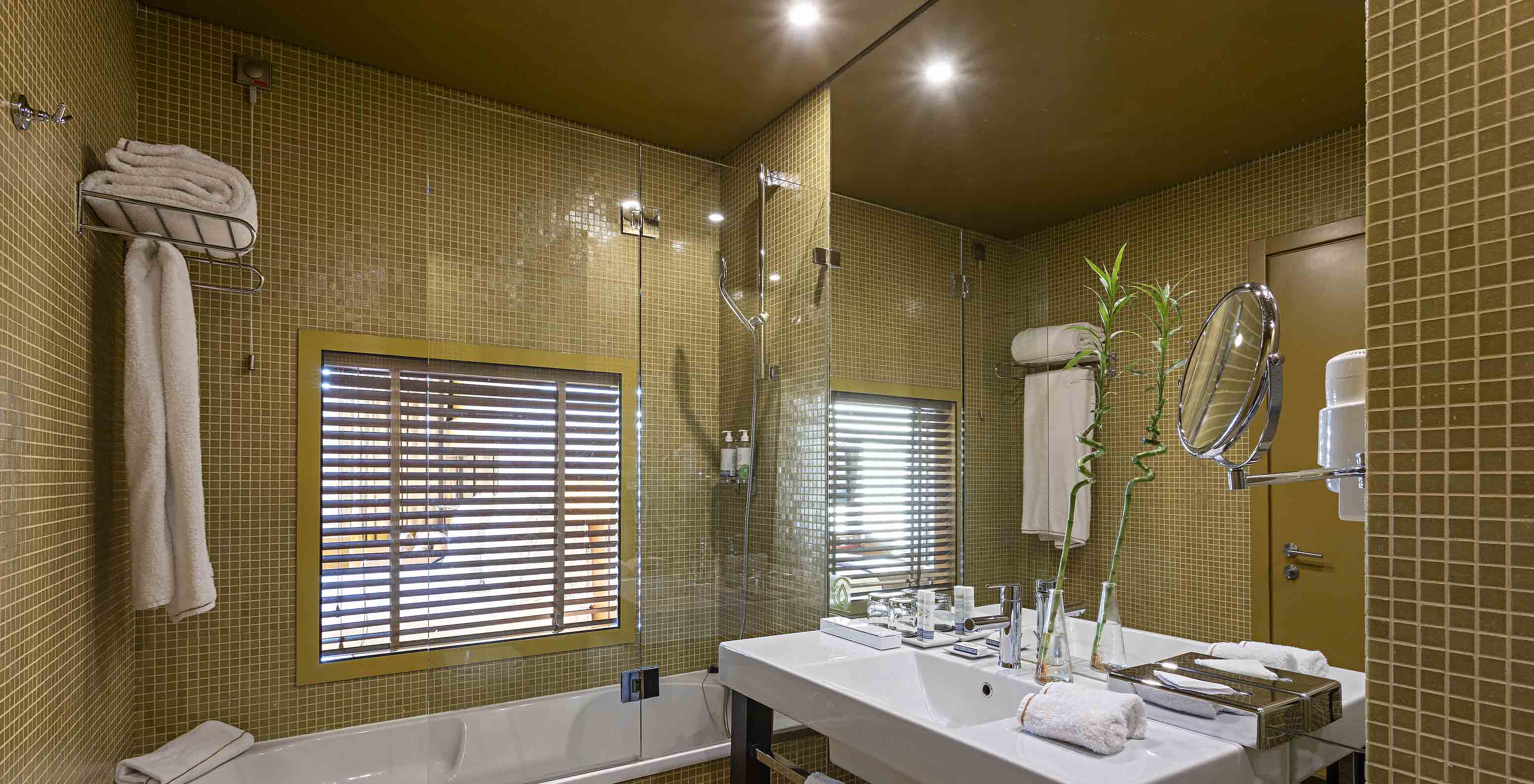 De Executive Superior heeft een badkamer met een bad en een raam naar de slaapkamer