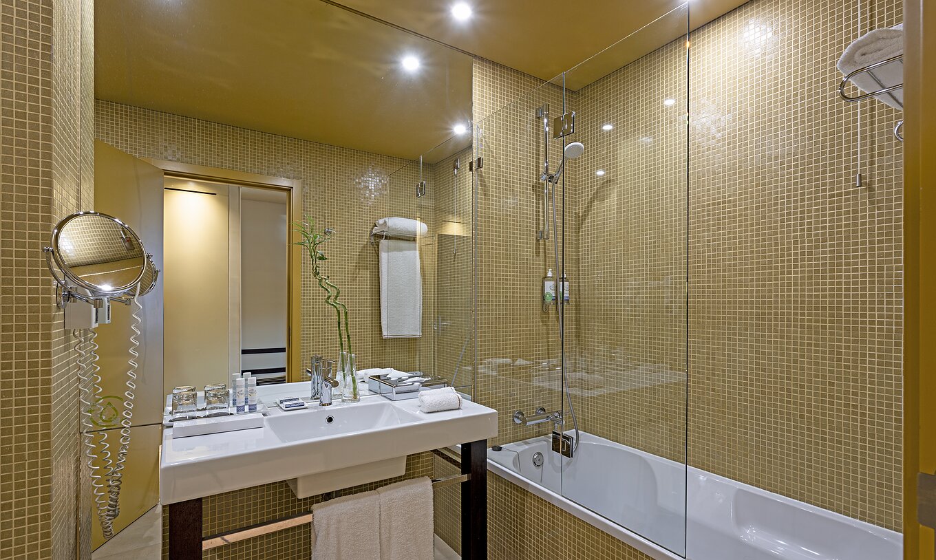 De Superior kamer van Pestana Palácio do Freixo heeft een badkamer met gele tegels, wastafel en een bad
