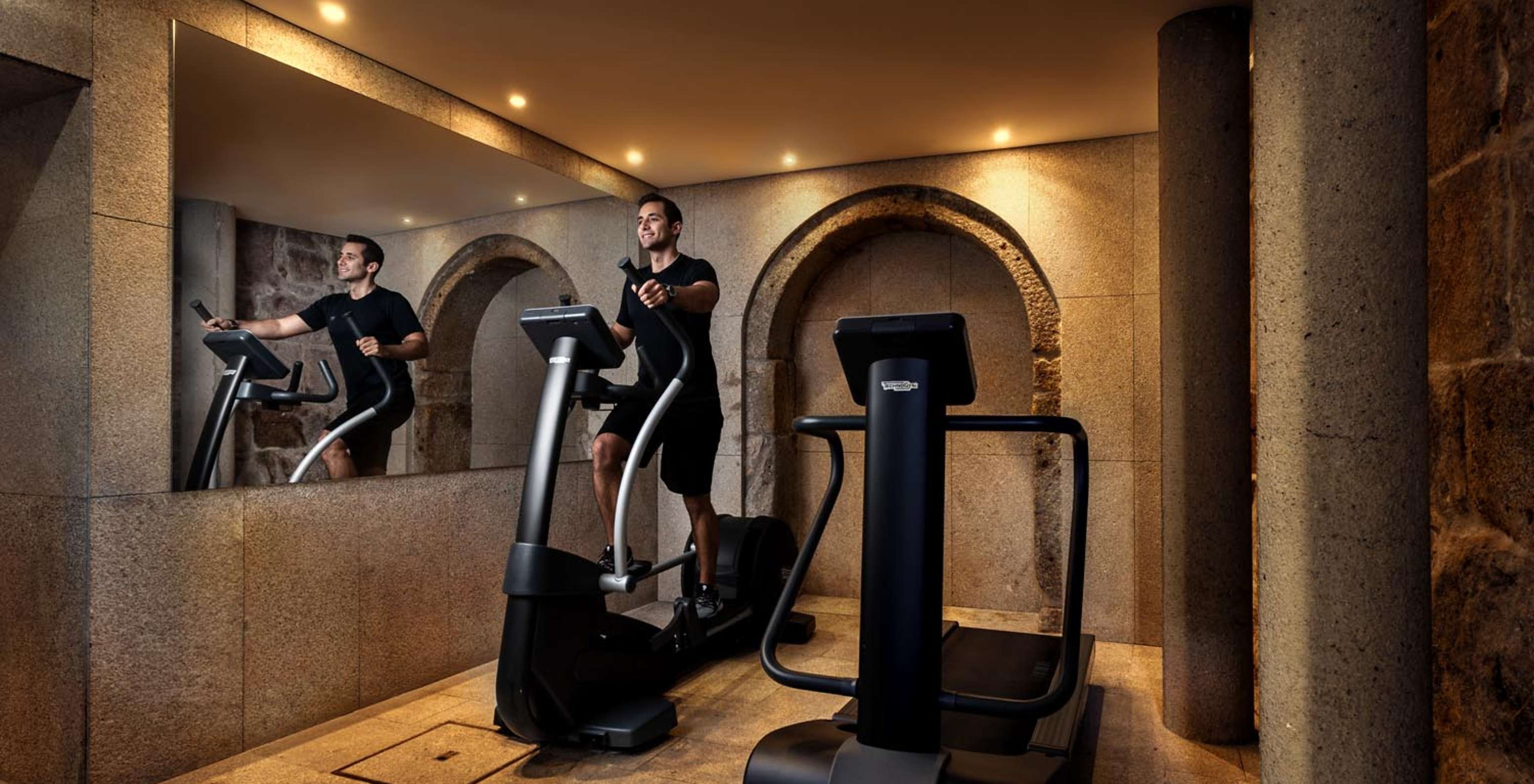 Persoon traint op de fitnessapparaten van Pestana Vintage Porto, een Hotel op Praça da Ribeira, Porto