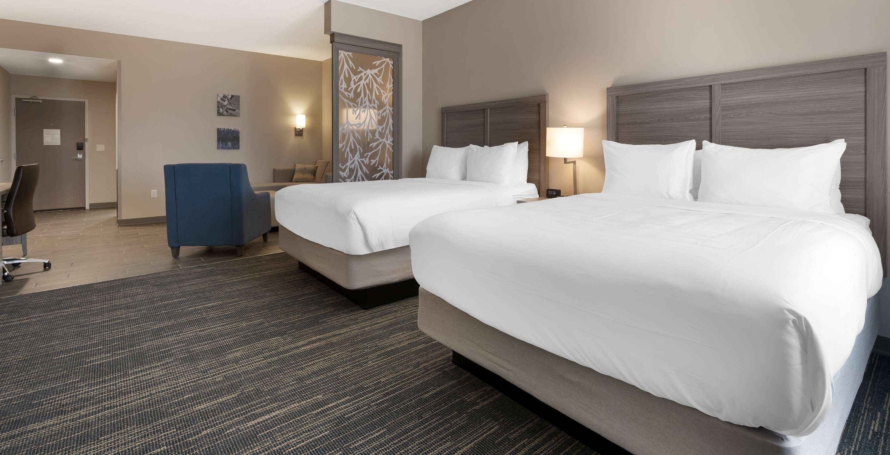 De Master Double Queen Suite Van Pestana Orlando Suites Lake Buena Vista Heeft Twee Tweepersoonsbedden En Een Fauteuil