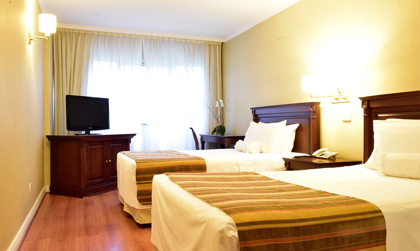 O quarto Twin Deluxe do Pestana Buenos Aires conta com duas camas individuais, mesa de cabeceira, televisão e secretária