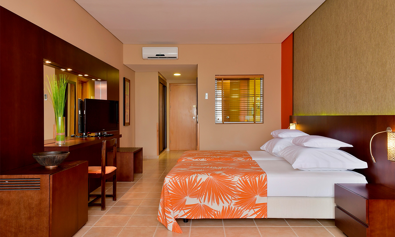 O quarto Standard do Pestana Tropico conta com duas camas individuais, televisão, mesa de cabeceira, espelho e uma cadeira