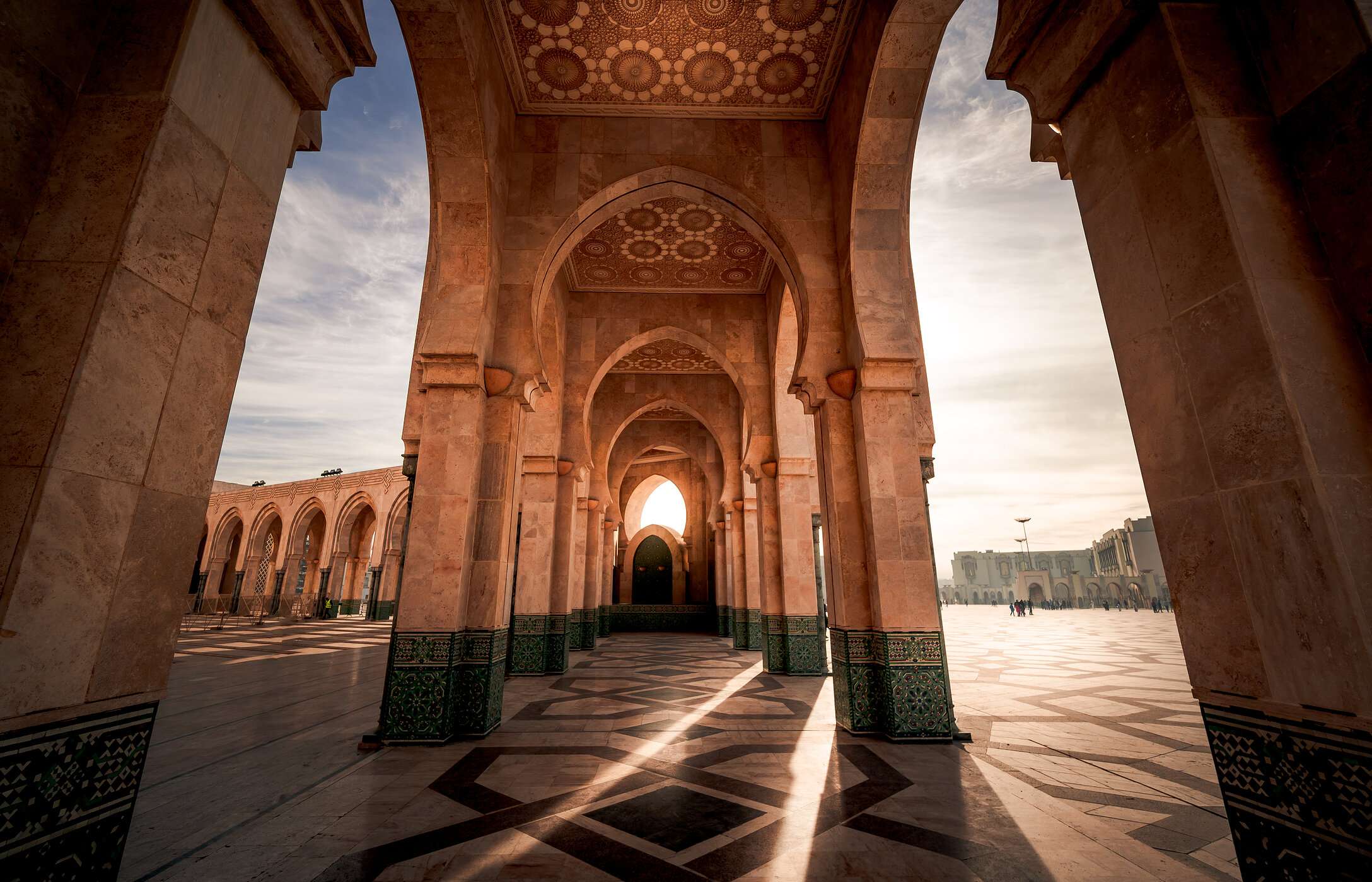 Vista nas arcadas da Mesquita de Hassan II em Casablanca, com uma luz de final de dia a incidir na arquitetura