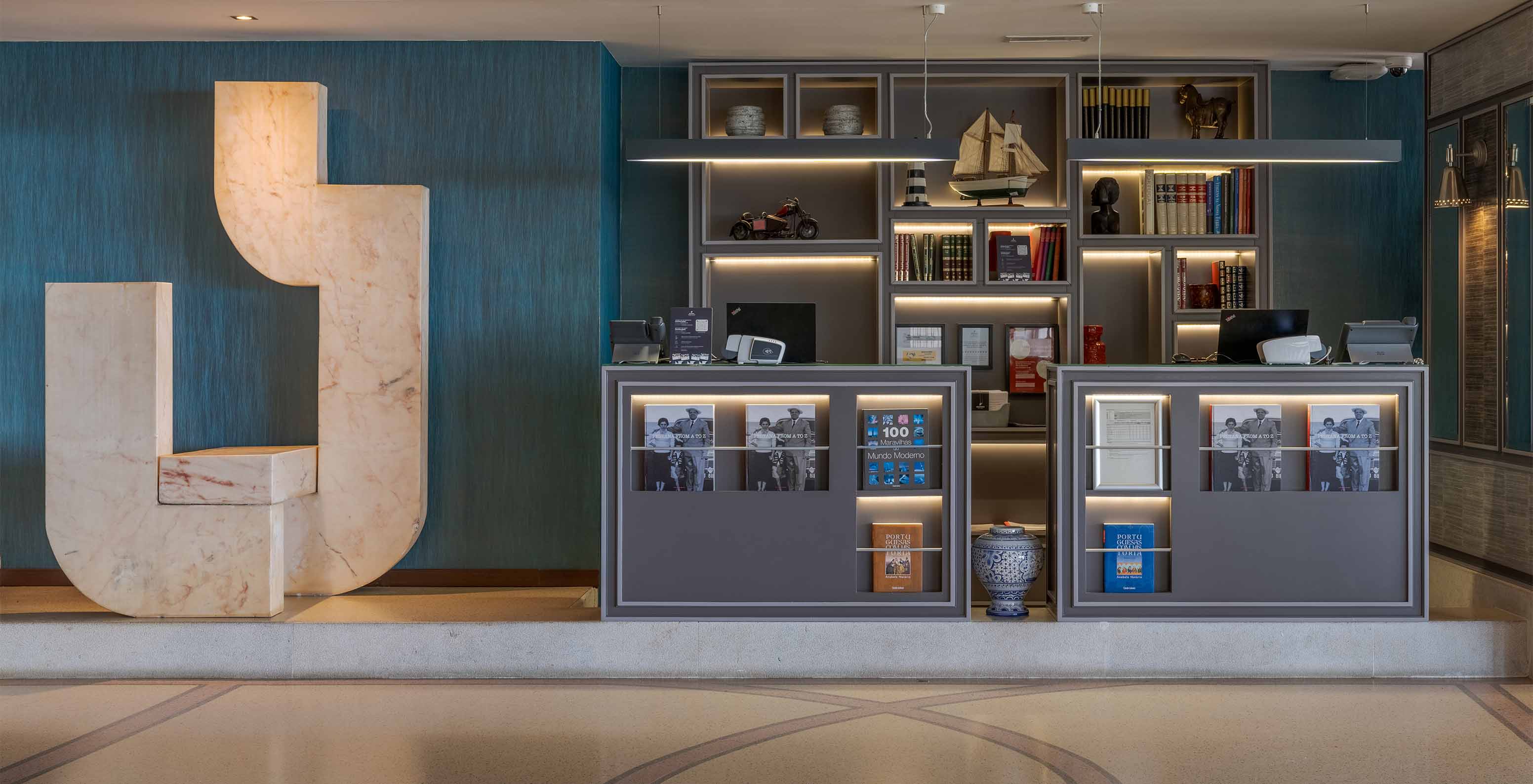 Receção com decoração elegante, com computadores e livros do Pestana Alvor Praia, Hotel com SPA, Piscina e Acesso à Praia