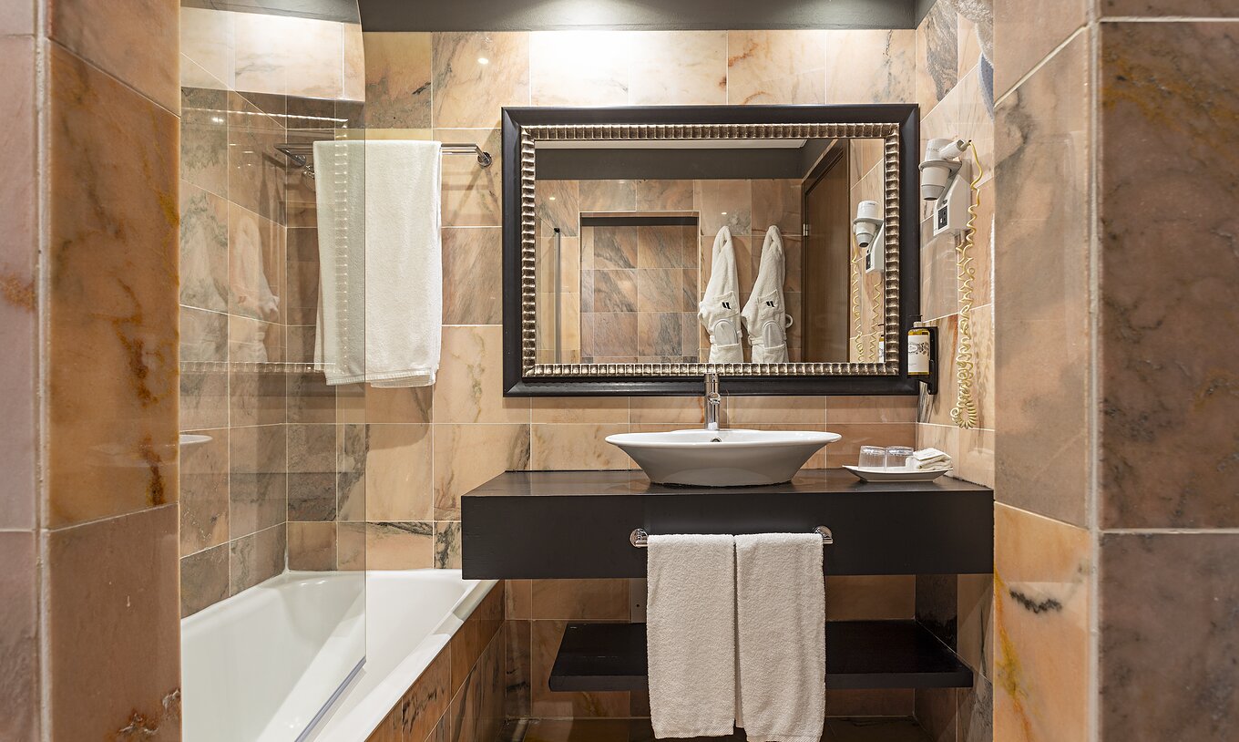 A Cliff Studio do Pestana Alvor Praia tem uma casa de banho com uma banheira, dois roupões e um secador de cabelo