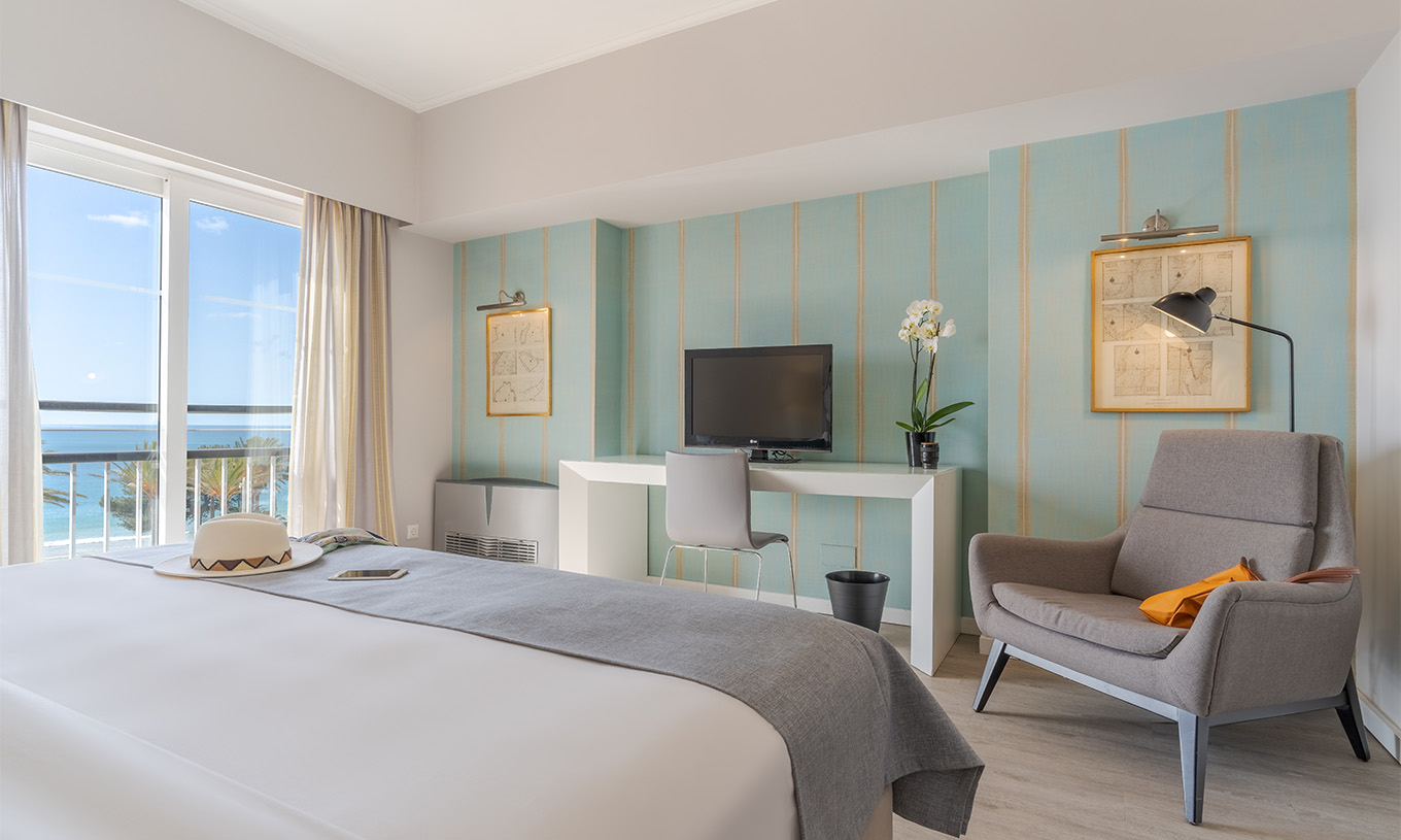 A Suite Luxo Vista Mar do Pestana Alvor Praia tem cama de casal, cadeirão, secretária com televisão e janela com vista mar