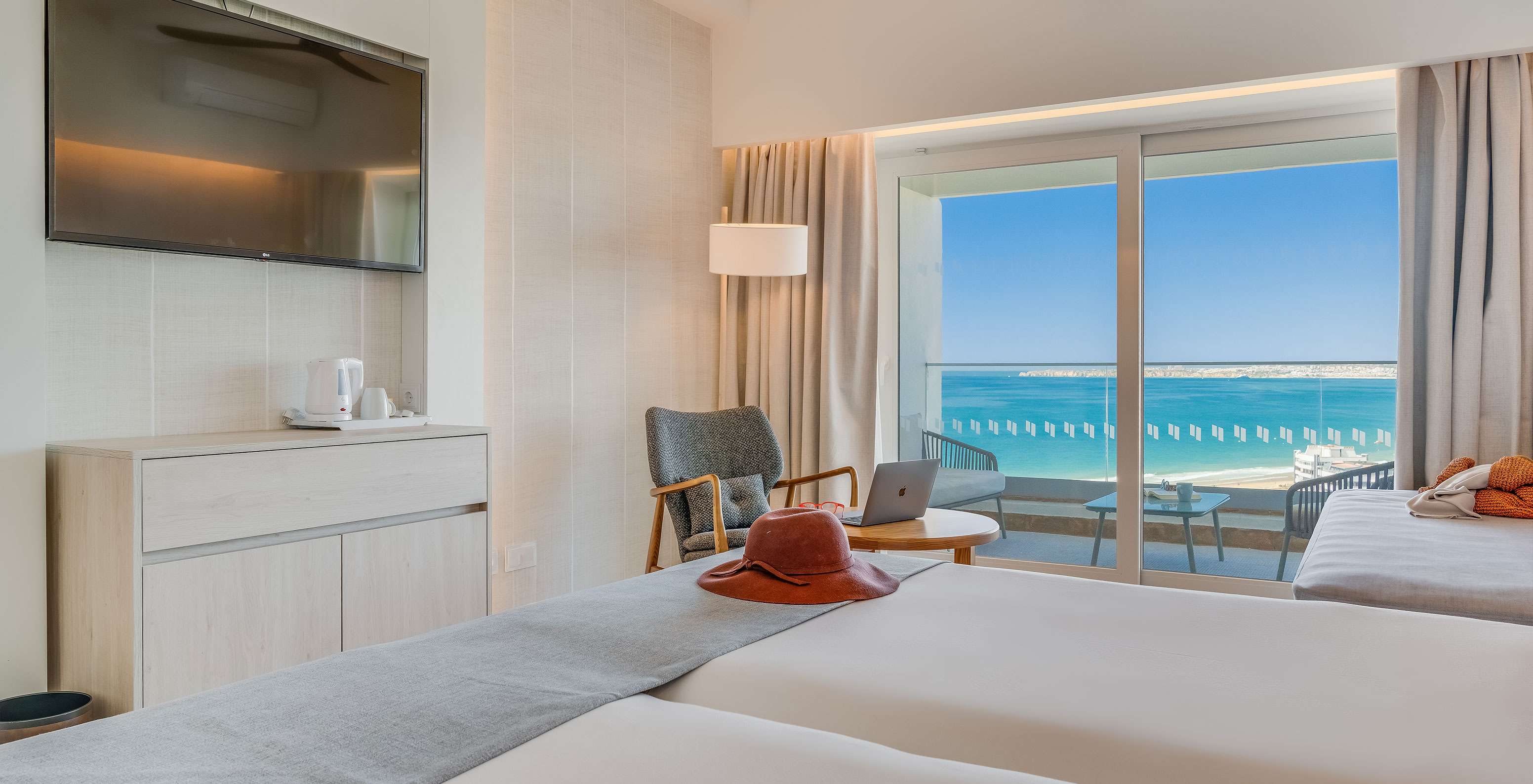 O Quarto Familiar do Pestana Blue Alvor Beach tem duas camas com lençóis brancos e uma televisão no fundo da cama