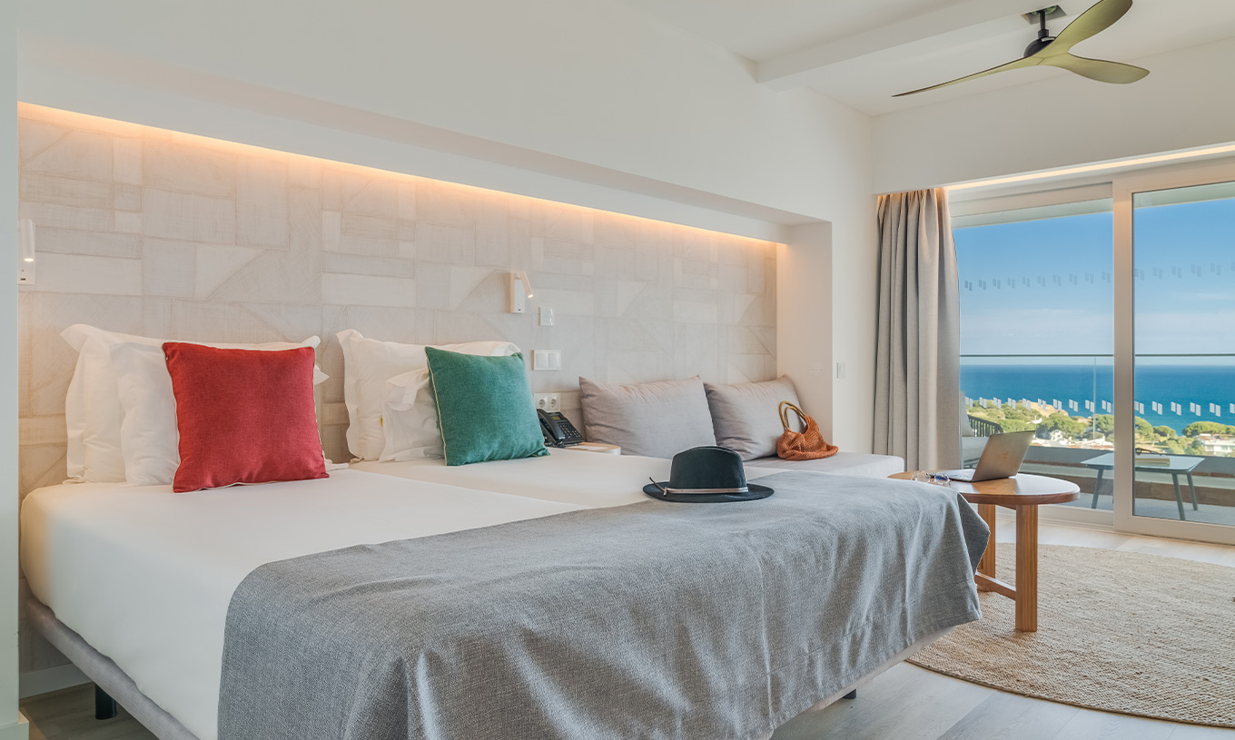 O Quarto Clássico Vista Mar do Pestana Blue Alvor Beach tem duas camas individuais com lençóis brancos e um sofá