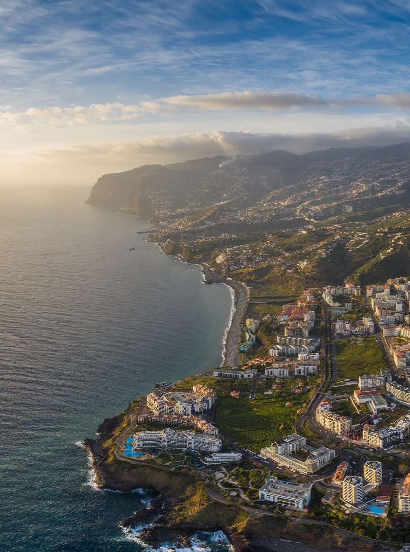 Vista aérea da cidade do Funchal, na Madeira, com áreas urbanas densas e montanhas ao fundo