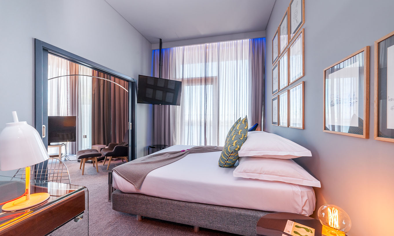 A CR7 Suite do Pestana CR7 Funchal tem um quarto co uma cama de casal, uma televisão presa na parede e uma janela