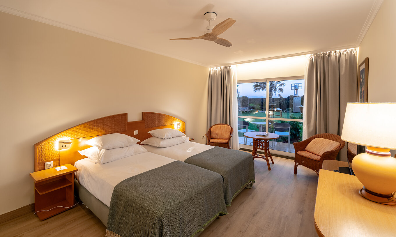 O Classic Pool View do Pestana Ocean Bay All Inclusive tem duas camas individuais unidas com vista para o jardim 