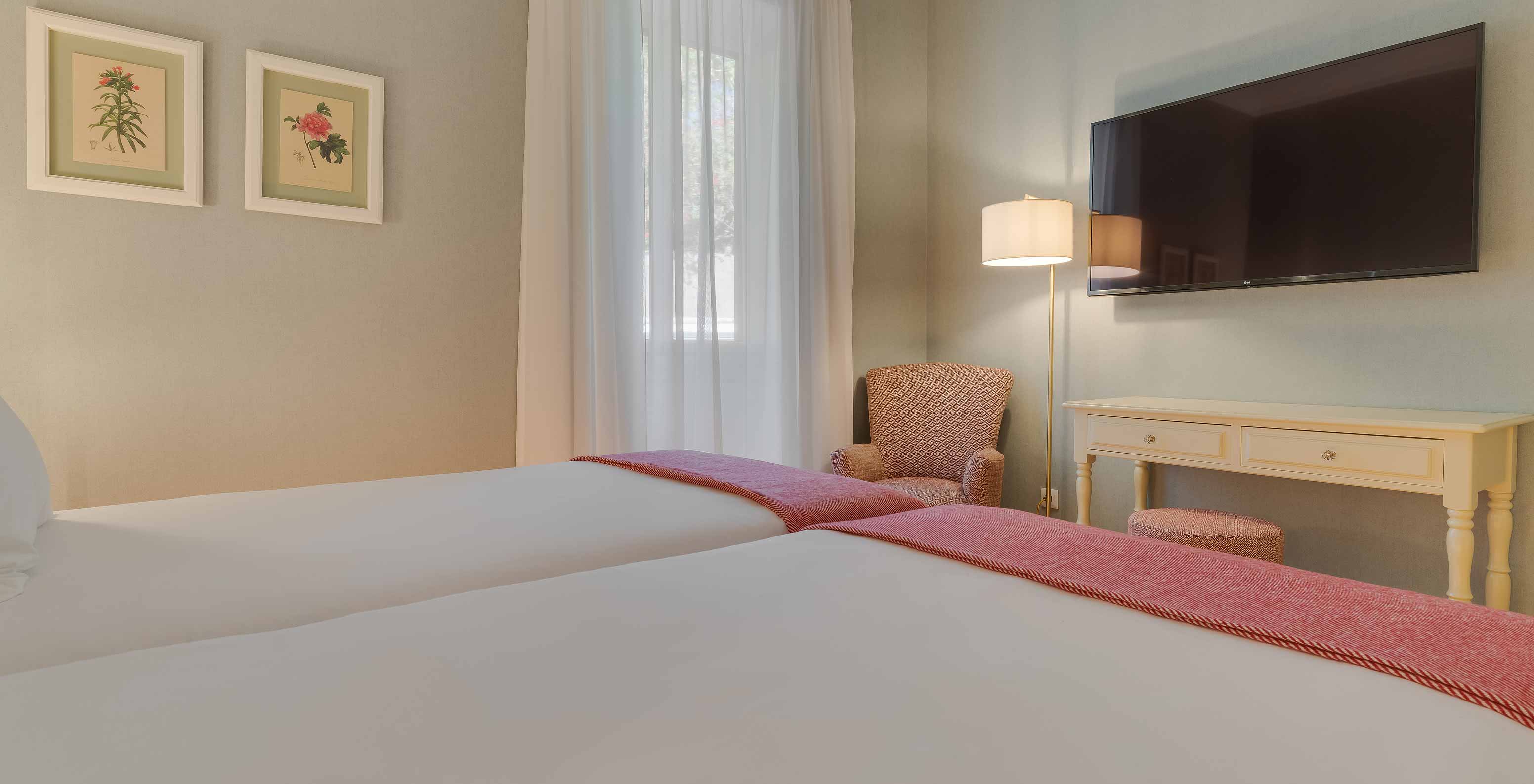 O quarto Clássico do Pestana Quinta Perestrello tem duas camas individuais e uma televisão