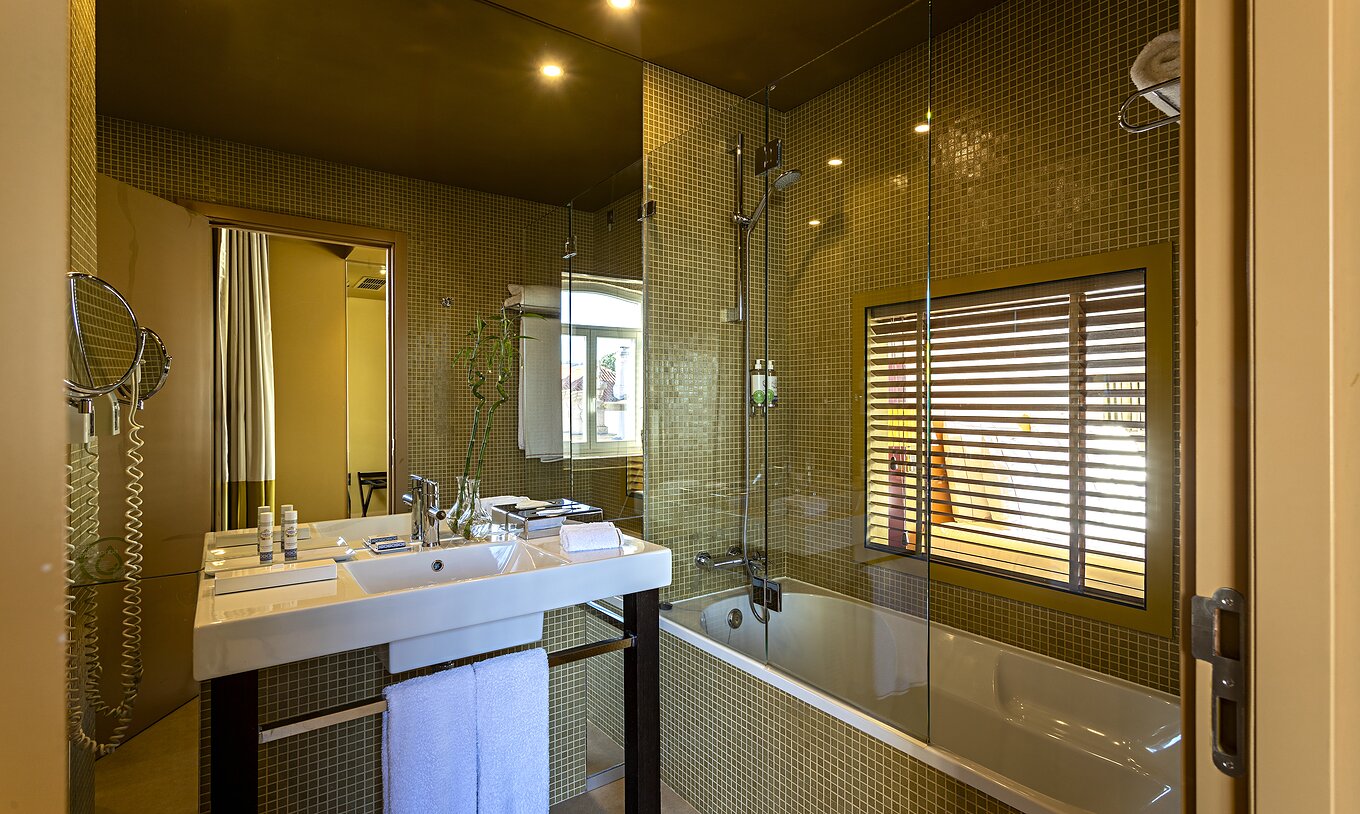 O Deluxe Grand View do Pestana Palácio do Freixo tem uma casa de banho com banheira e uma janela para o quarto