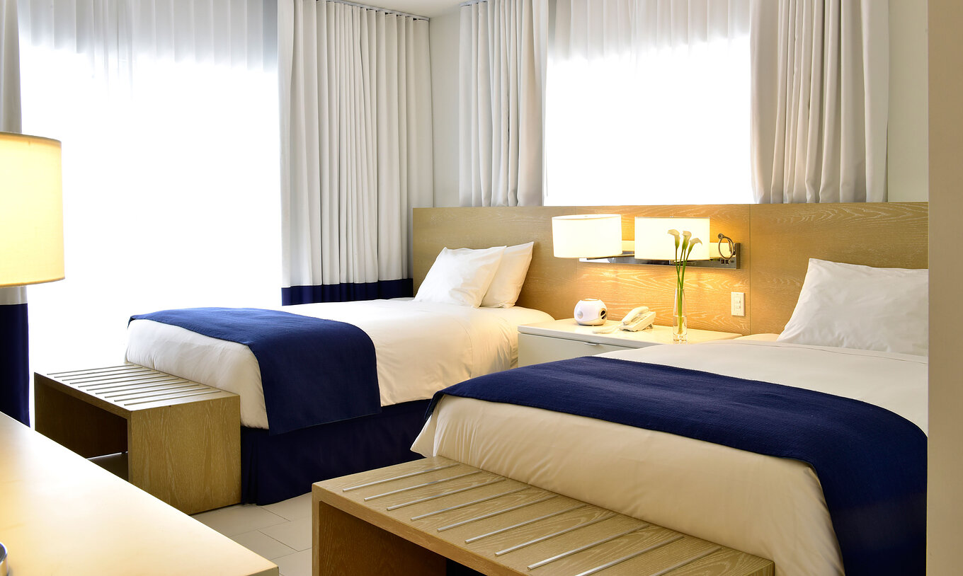 O Superior Duplo com Varanda do Pestana Miami South Beach é um quarto com duas camas, decoração clara e minimalista