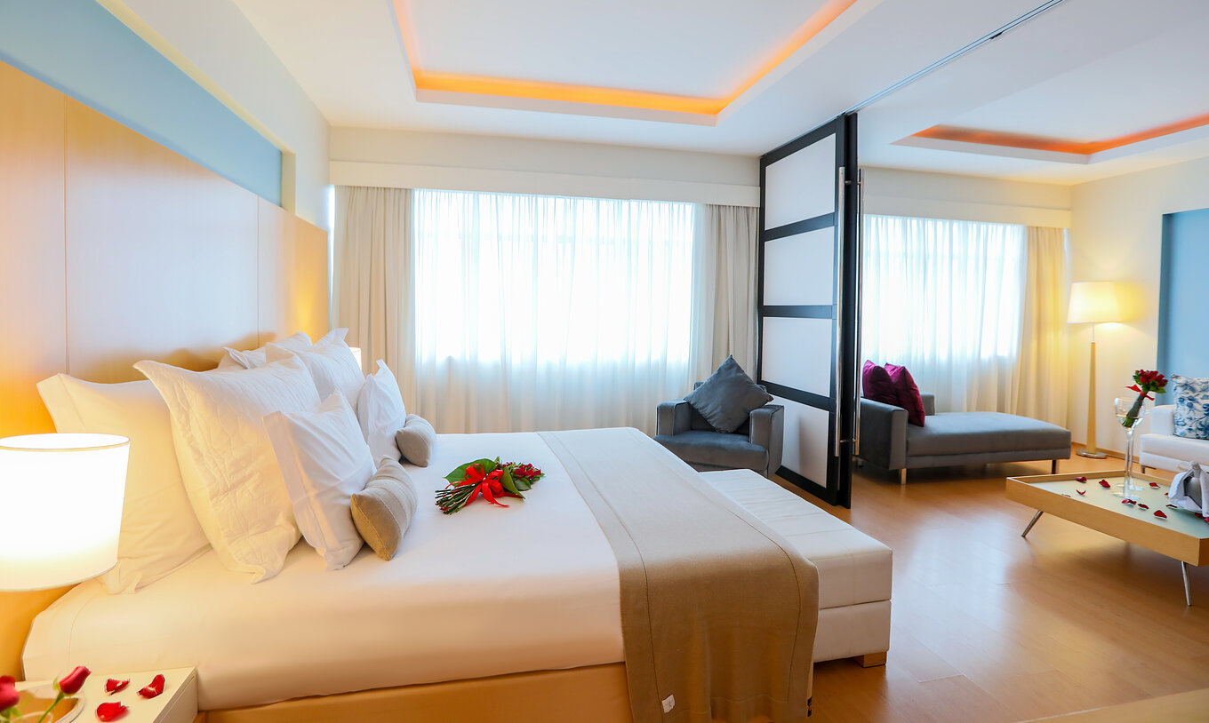 A King Master Suite do Pestana Curitiba tem um quarto com cama de casal e uma sala com sofá que pode ser uma cama extra