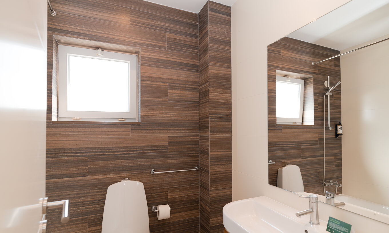 A Villa 1 Quarto Vista Jardim do Pestana Alvor Beach Villas tem uma casa de banho com lavatório, espelho e uma pequena janela