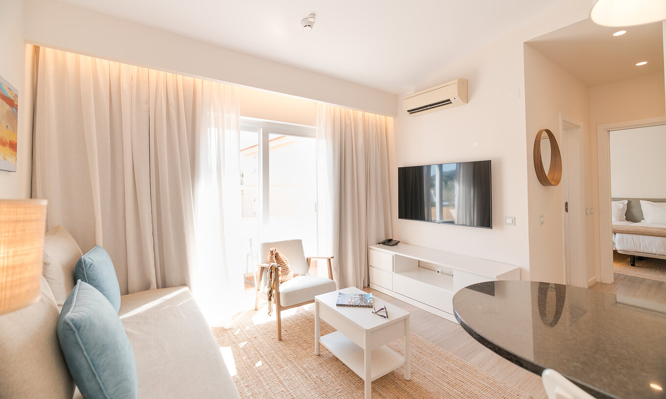 A Villa 1 Quarto Vista Jardim do Pestana Alvor Beach Villas tem uma sala com sofá, televisão, ar condicionado e varanda