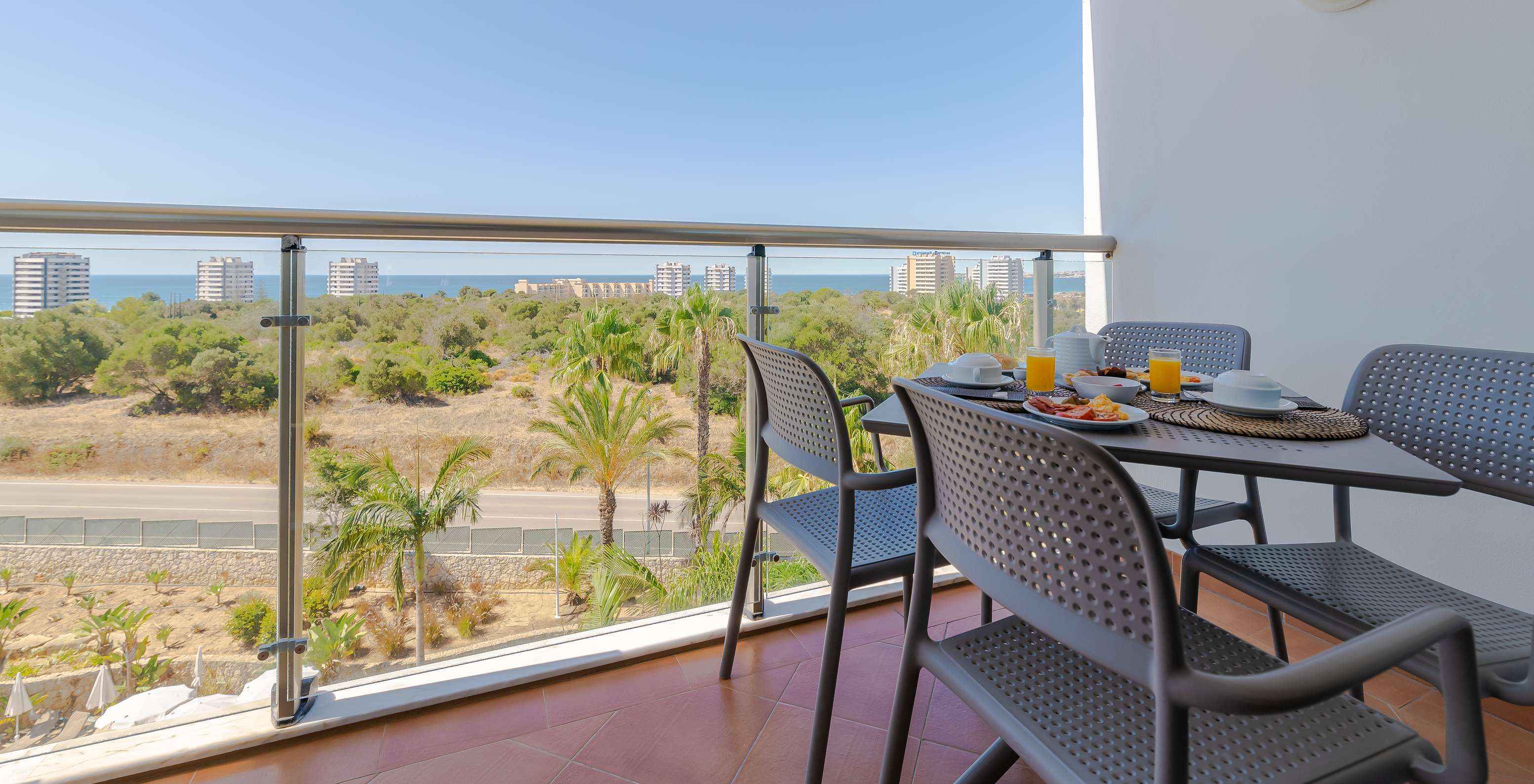 O T1 - com 1 Quarto Superior do Pestana Alvor Park tem uma varanda com uma mesa e cadeiras com vista para o mar