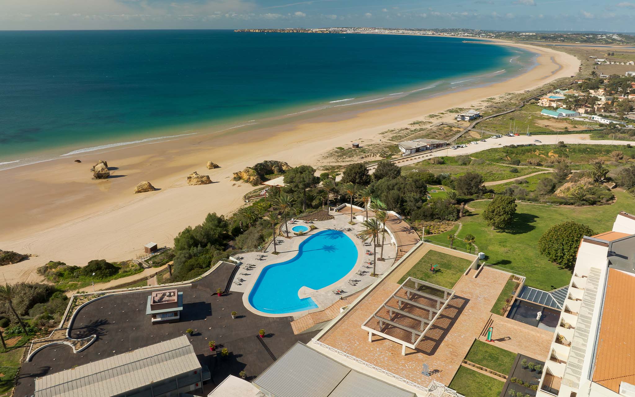 Vista de cima para a piscina do Pestana Alvor Praia, com acesso direto à longa extensão de areia, da Praia dos Três Irmãos