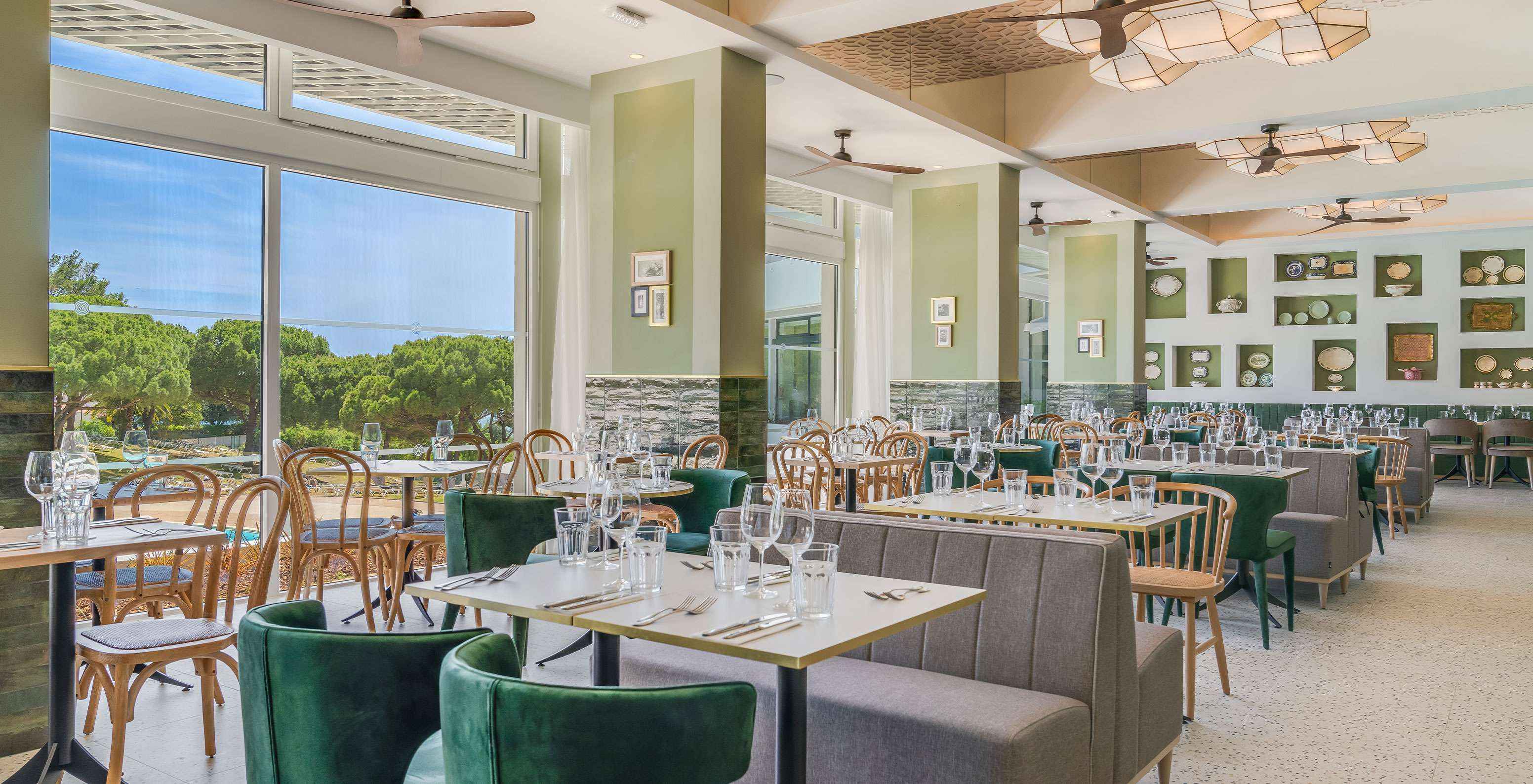 O restaurante Luigi, do Hotel Tudo Incluído no Algarve, tem mesas com sofás e cadeiras confortáveis para fazer uma refeição