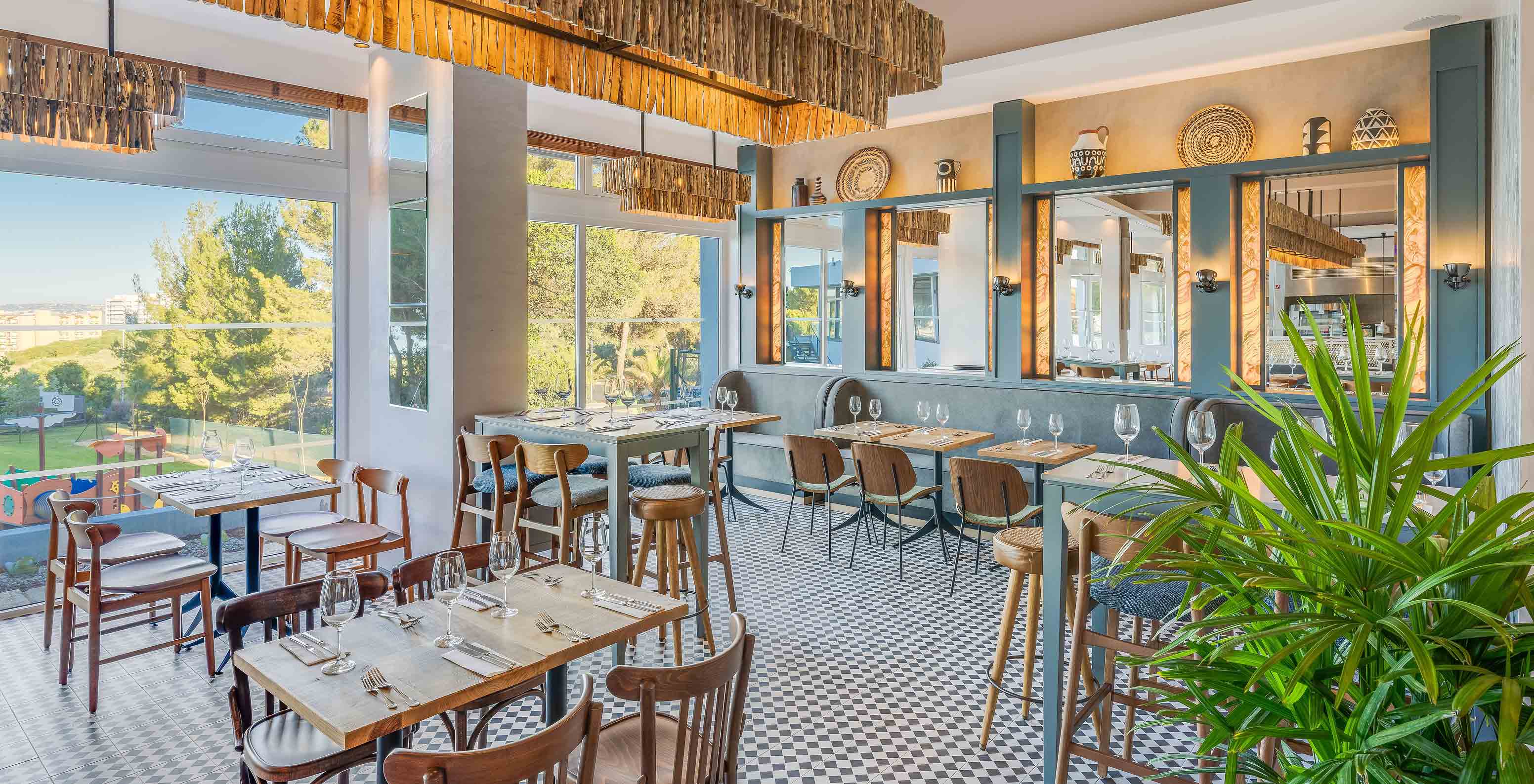 O restaurante Fuego, do Hotel Tudo Incluído no Algarve, tem uma decoração moderna e várias mesas com vista jardim