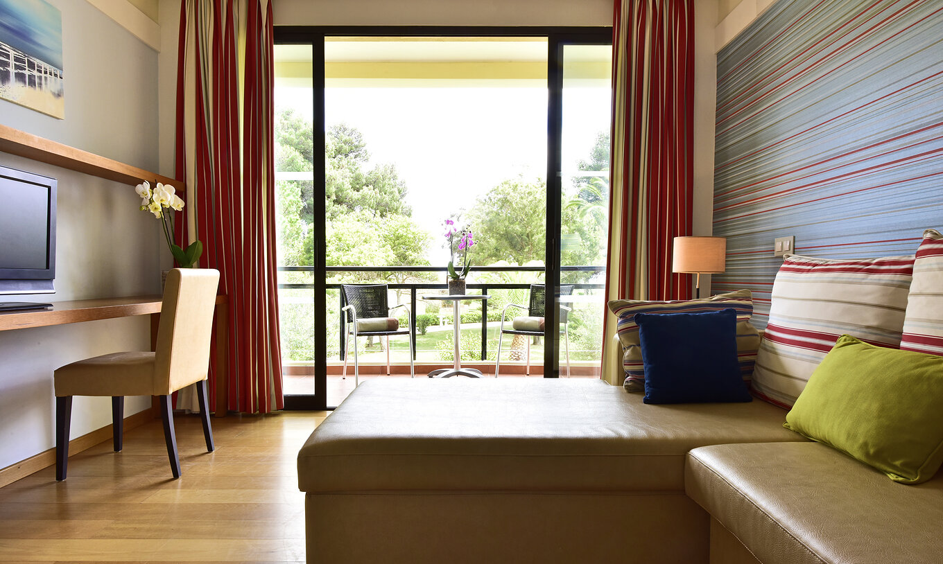 O Suite Standard do Pestana Dom João II conta com uma varanda com vista para o jardim, um sofá com chaise longue e televisão