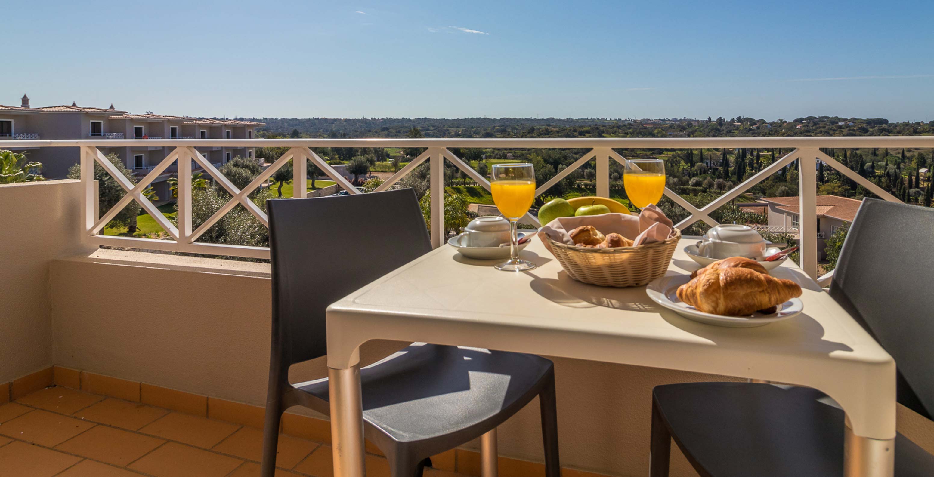 O Studio do Pestana Gramacho Residences tem uma mesa ao ar livre em cenário ensolarado e acolhedor com vegetação.