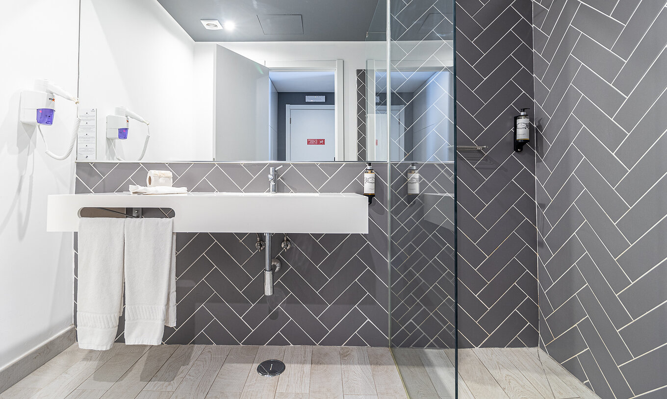 O Quarto Clássico Vista Piscina do Pestana Gramacho Residences tem uma casa de banho com walk-in shower, lavatório e espelho