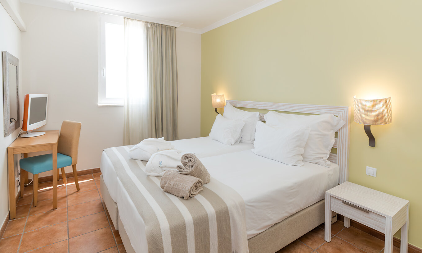 A Suite Superior Vista Mar do Pestana Viking conta com duas camas individuais, mesa de cabeceira, televisão e espelho