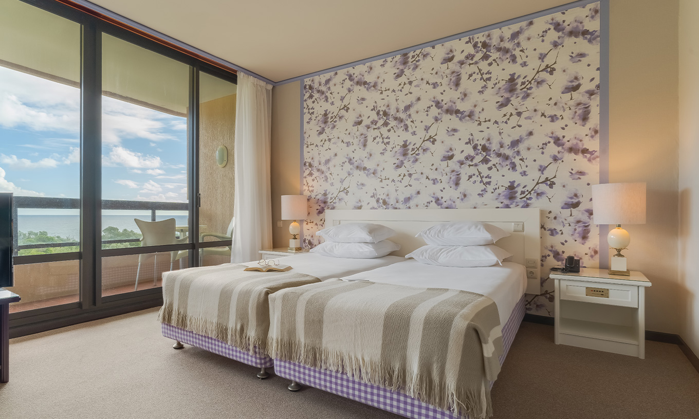 Na Junior Suite Vista Jardim do Pestana Bahia Praia , as camas ficam ao lado da varanda, com vista para jardins e para o mar