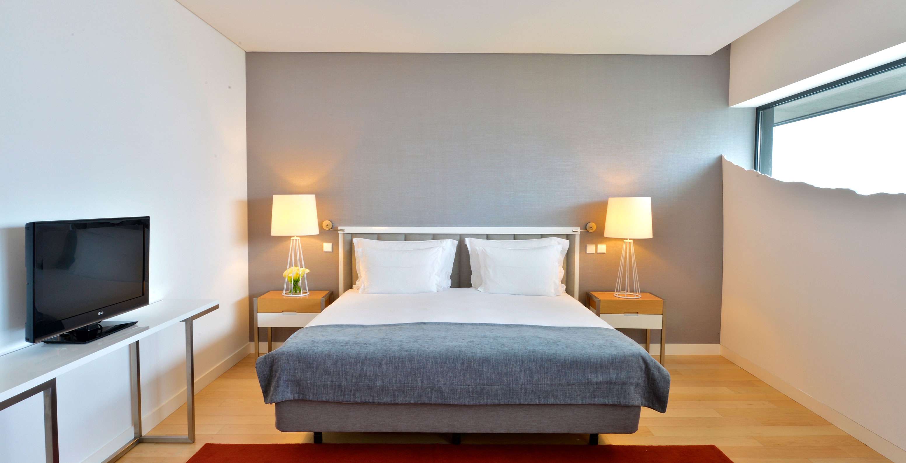 O Quarto Duplo Superior do Pestana Cidadela Cascais tem uma cama de casal, duas mesas de cabeceira e um tapete vermelho