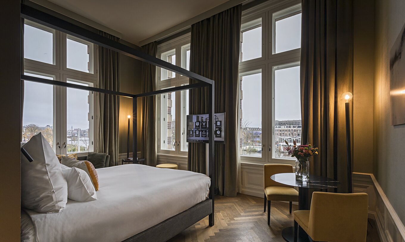 A Presidencial Suite - River View do Pestana Amsterdam Riverside tem uma cama de casal com dossel e televisão