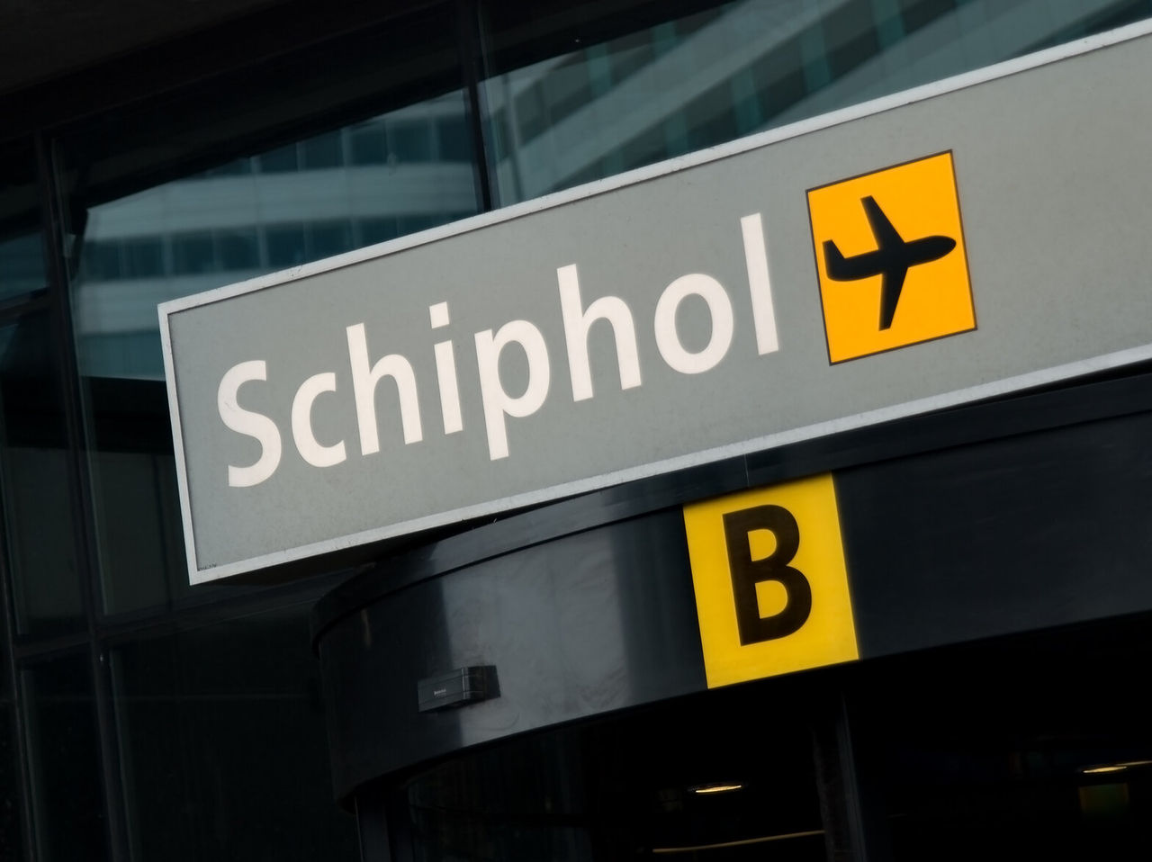 Graues Schild mit weißen Buchstaben, das Terminal B am Flughafen Schiphol in Amsterdam, Niederlande anzeigt